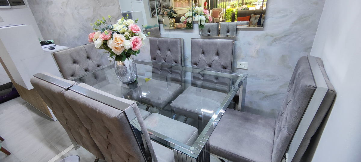 Comedor de acero de 6 sillas con mesa de vidrio y sillas grises capitoné con acentos de acero - Deco Muebles